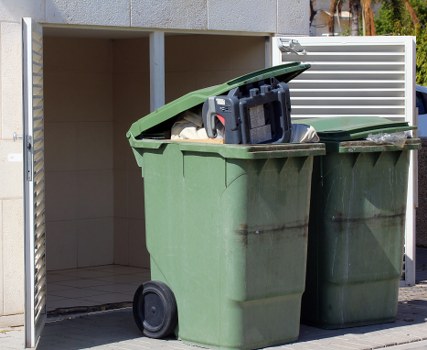 Waste vehicles parked with cones and signage for safe operation